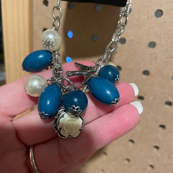 Silver charm bracelet w/teal beads, pearls, dove, and a “white icing” flower.